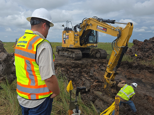 Pipeline excavation work with construction crew and heavy equipment