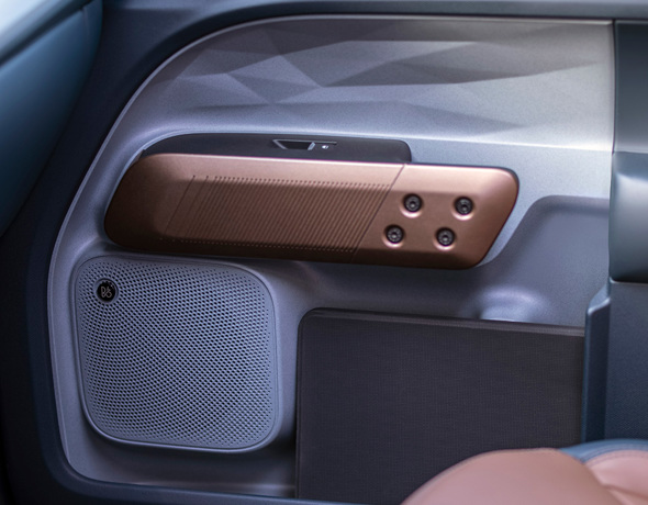 Close-up of a modern vehicle interior door panel featuring a metallic bronze accent trim.