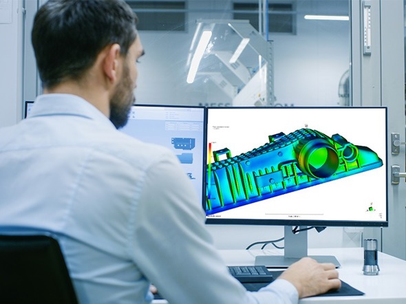 Employee designing equipment in a computer lab using computer-aided engineering (CAE)