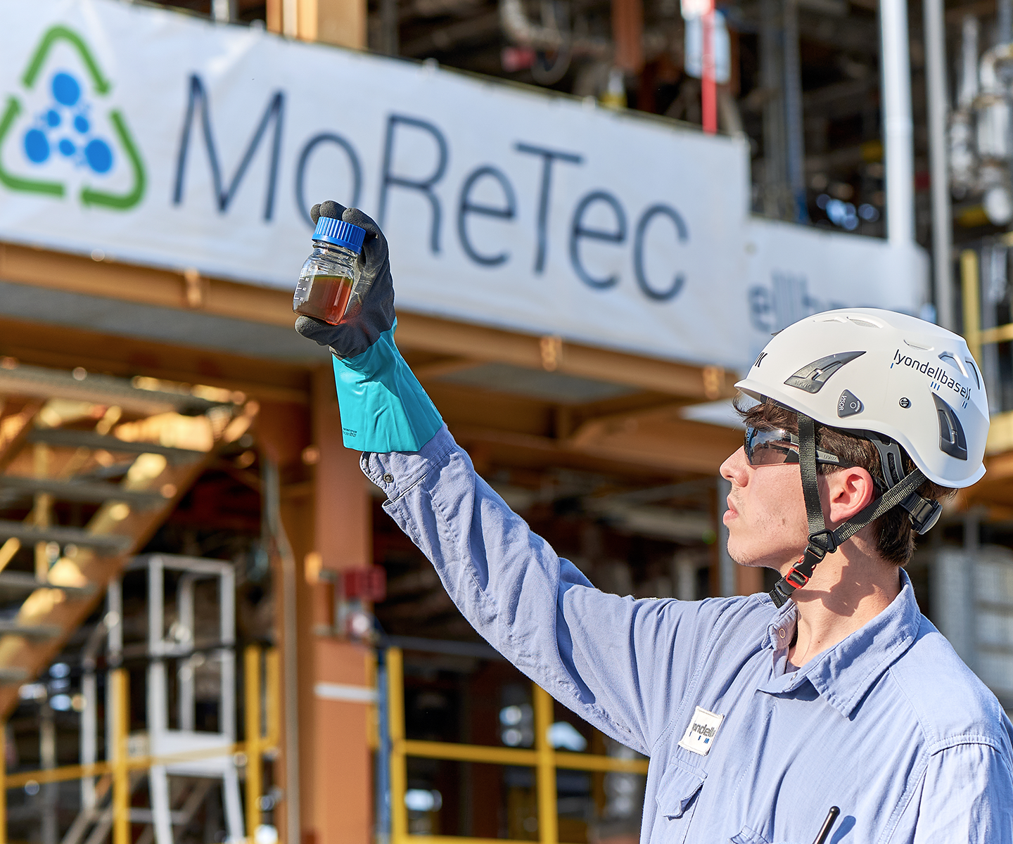 An LYB employee holds a MoreTec container containing processed material.