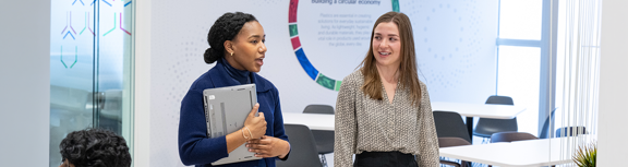 Employees having a discussion in a modern meeting space.